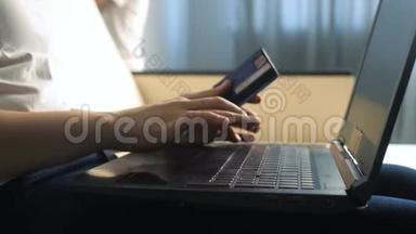 女孩用笔记本电脑数字平板电脑制作网上销售购物概念。 黑发女人躺在沙发上看生活用品店